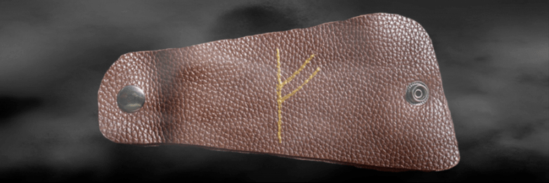 Fehu rune ar an gcraiceann mar amulet de luck maith